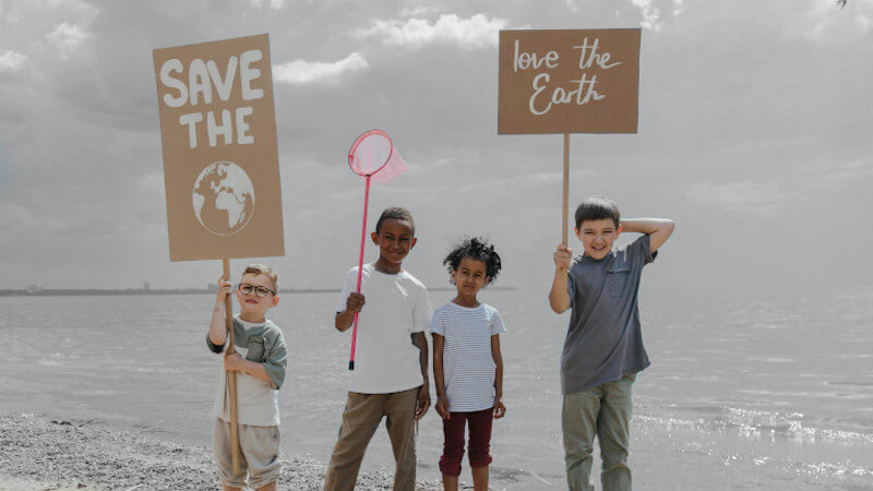des adolescents avec des panneaux pour sensibiliser les enfants à l'écologie