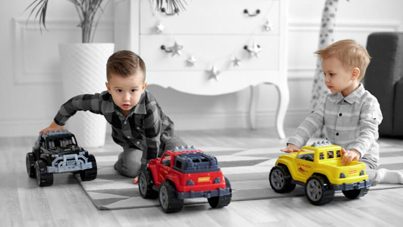 deux enfants jouant avec des jouets voitures miniatures