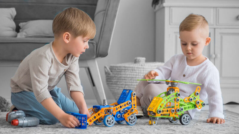 deux garçons avec des jouets en plastique collaboratifs