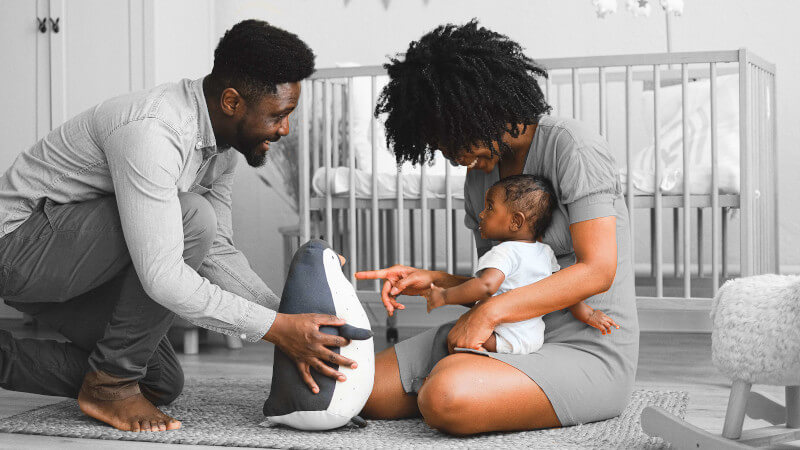 deux parents avec un enfant avec une peluche géante