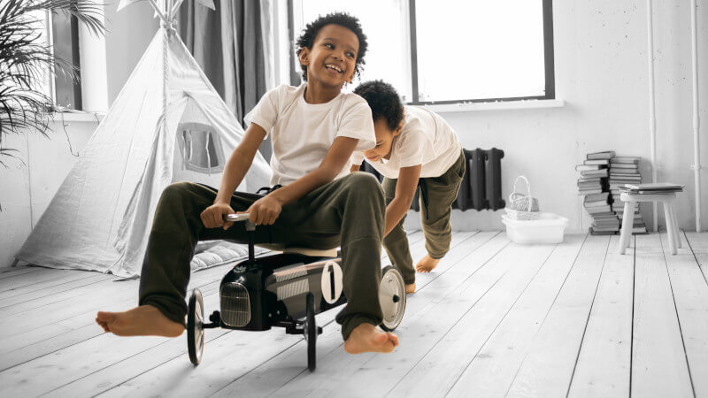 dos niños con un correpasillos metálico