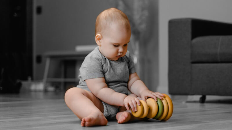 ein baby mit stapelspielzeug aus holz