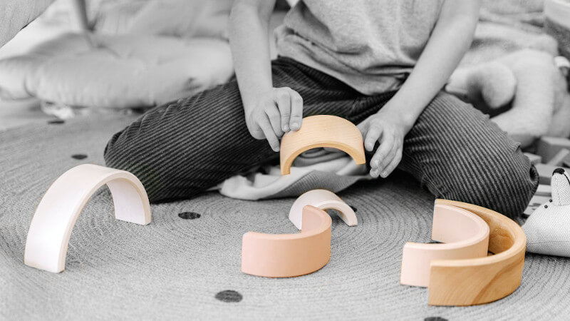 ein kind mit ökologischem holzspielzeug