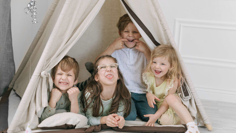 quatre enfants qui jouent dans tipi de jeu