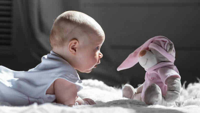 un bébé avec une peluche enfant