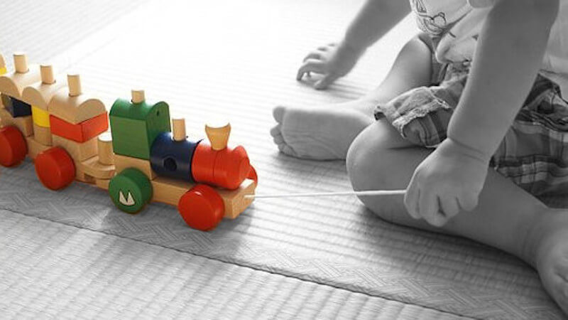 un bébé jouant avec un jouet a tirer en bois premier âge