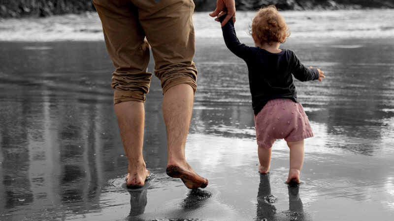 un bebe marchant debout avec son papa