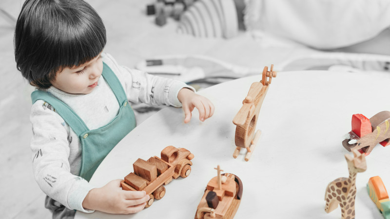 un enfant avec des jouets en bois brut