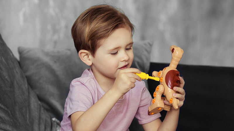 un enfant avec jouet figurine dinosaure