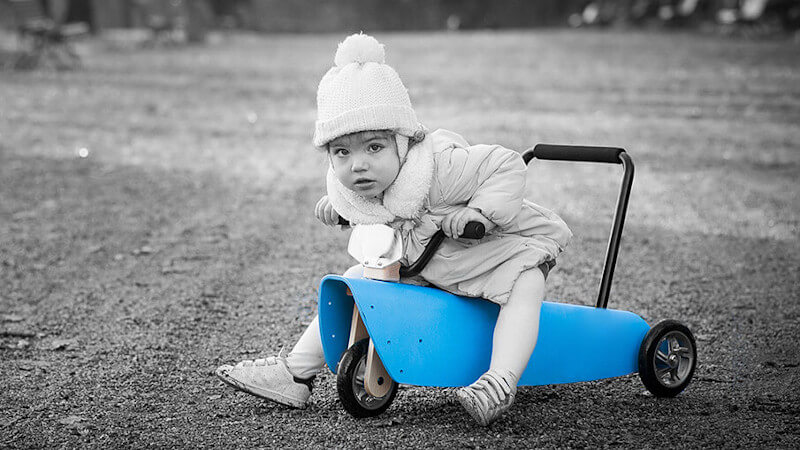 un enfant avec un jouet porteur bébé bleu en bois