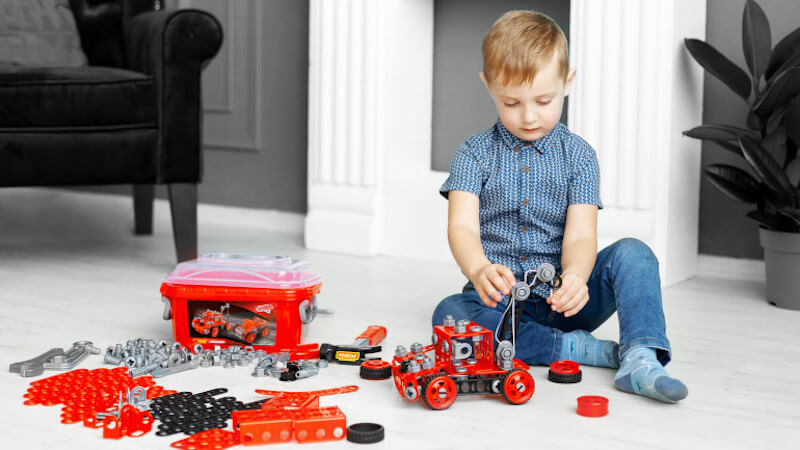 un enfant qui joue avec un jouet meccano