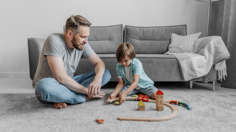 un enfant qui joue avec un train en bois miniature