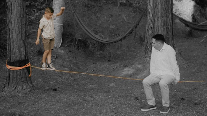 un enfant qui marche sur une slackline