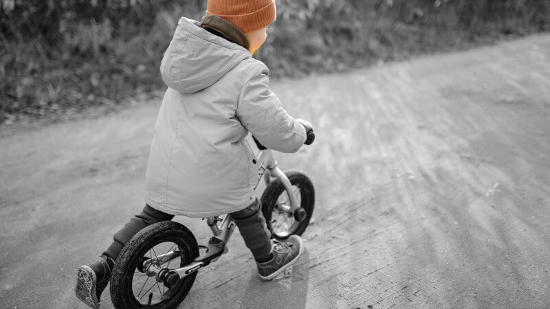 un jeune enfant assis sur une draisienne bebe