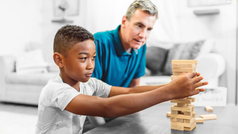 un jeune enfant qui joue avec un jeu de construction en bois naturel