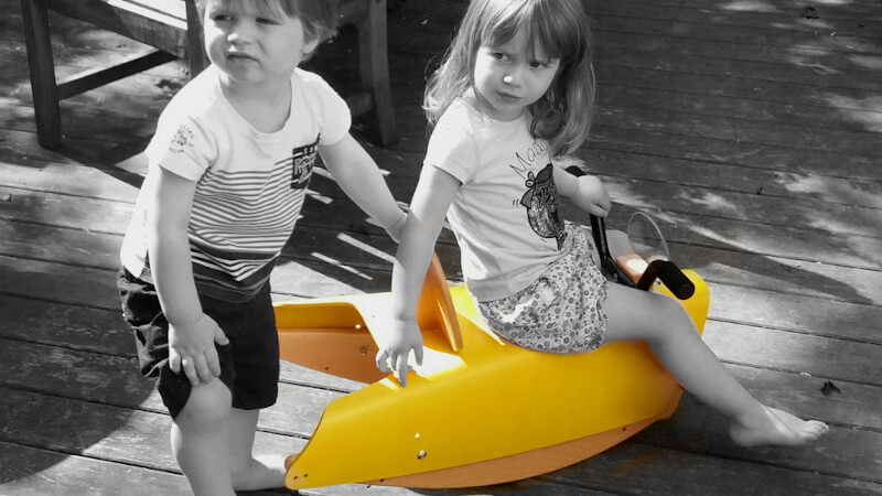 un jouet moto à bascule avec deux enfants