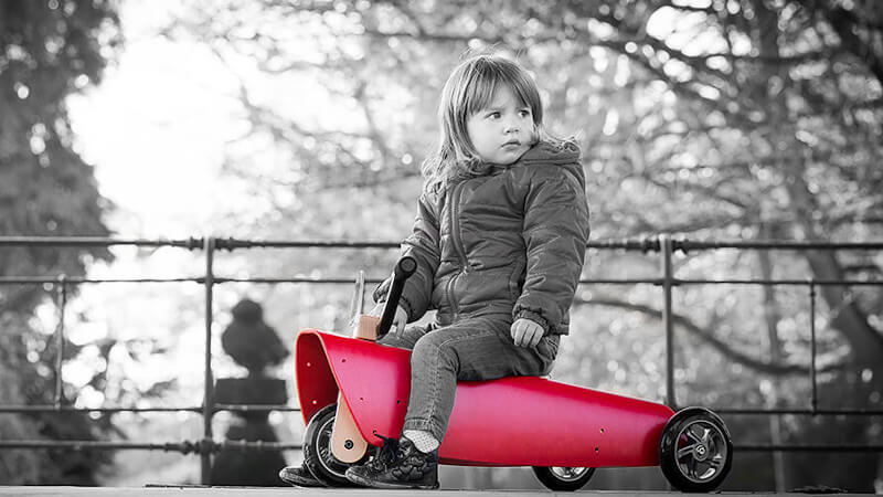 une jeune fille avec un manteau assise sur un porteur bébé