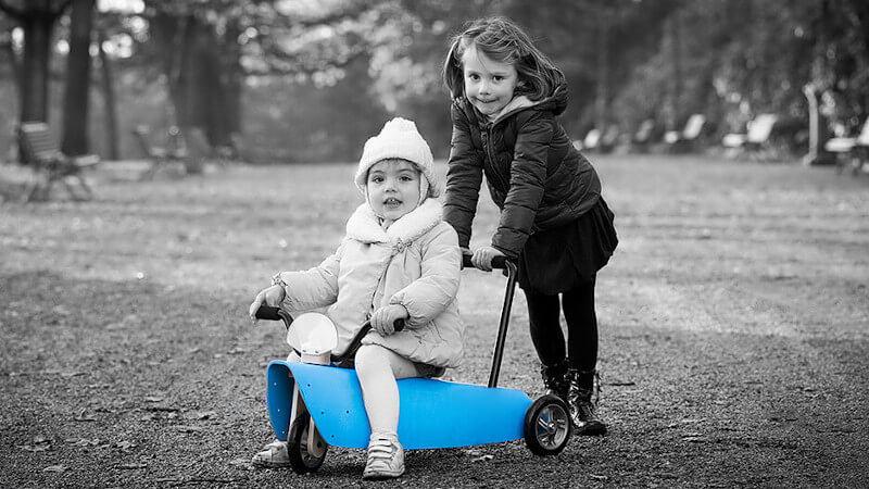 un jouet porteur en bois bleu avec deux enfants