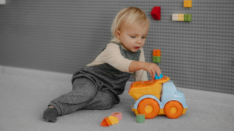 un niño jugando con un coche en miniatura 5