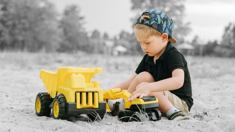 un petit garçon avec jouet camion miniature