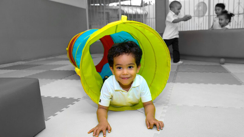 une enfant jouant dans un tunnel de jeu bebe
