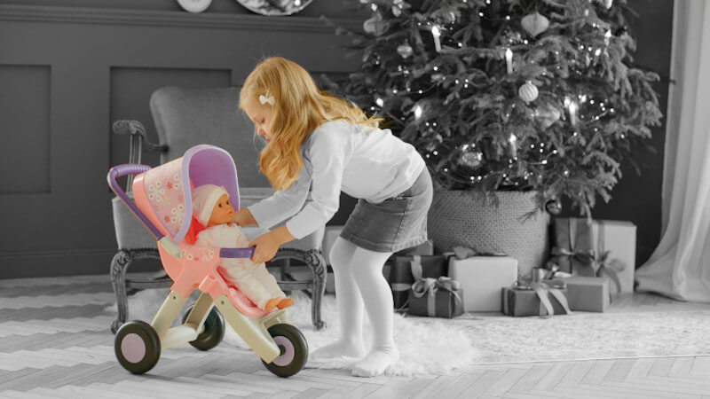 une fillette jouant avec des jouets d imitation poussette bébé