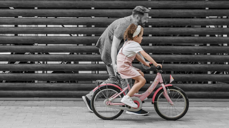 une jeune fille apprenant a faire du vélo