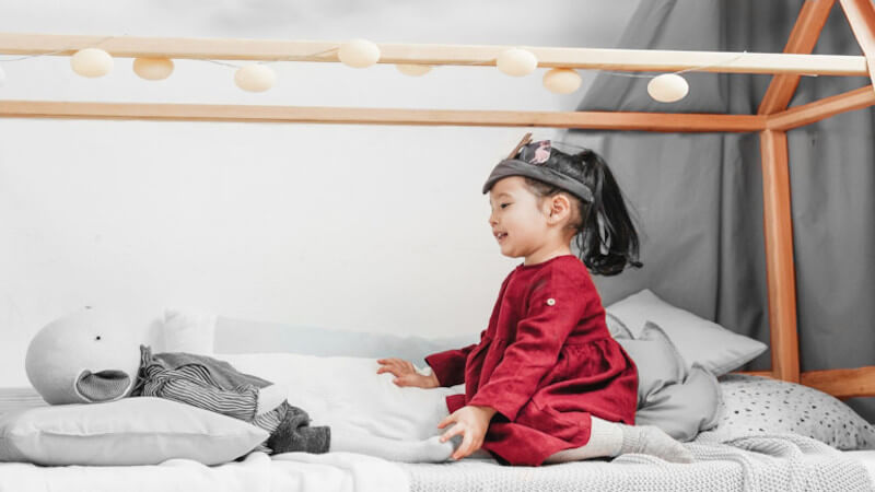 une jeune fille jouant dans un lit cabane enfant